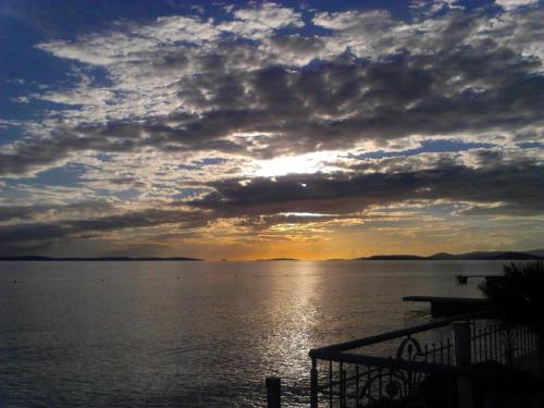 a sunset over a large body of water at Hotel Neva in Podstrana