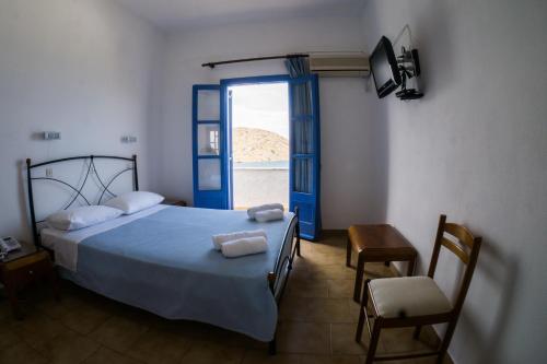 Blue Bay Hotel في سكالا: غرفة نوم بسرير وطاولة وكراسي