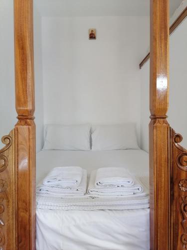 a bed with white sheets and wooden posts at Kalliopis Studio in Olympos