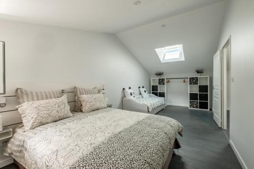 1 dormitorio blanco con 1 cama y 1 silla en Gîte la Grange du Moulin en Vendée, en Saint-Jean-de-Beugné