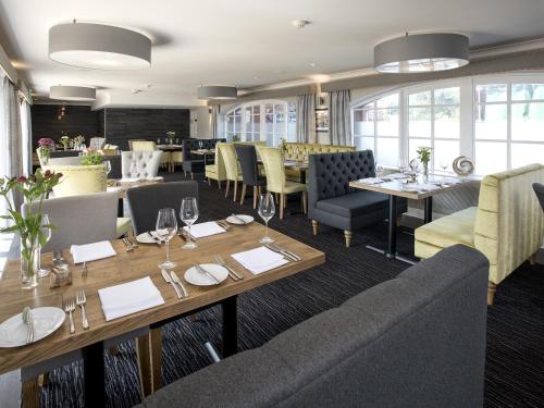 un comedor con mesas y sillas y un restaurante en The Old Hall Hotel en Caister-on-Sea