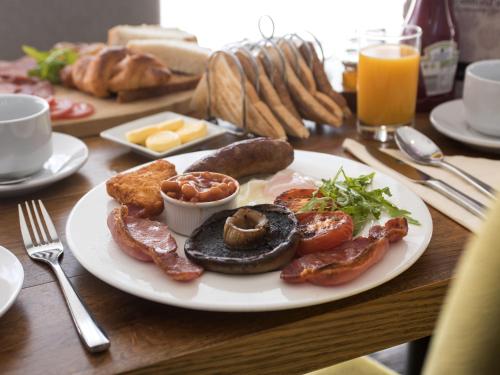 a plate of breakfast food on a wooden table at The Old Hall Hotel in Caister-on-Sea