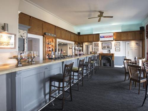 a bar with a row of chairs in a room at The Old Hall Hotel in Caister-on-Sea