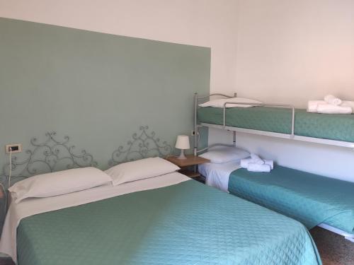 2 łóżka w pokoju z 2 łóżkami piętrowymi w obiekcie Hotel Imperia w mieście Marciana Marina