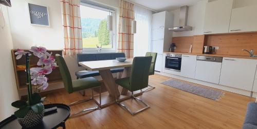 kuchnia i jadalnia ze stołem i krzesłami w obiekcie Apartment Life w mieście Radstadt