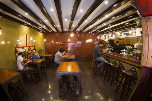 a group of people sitting at a bar in a restaurant at Chakana Hotel Boutique Centro in Quito