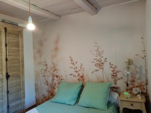 a bedroom with a bed with blue pillows at Echo du Maquis in Penta-Acquatella
