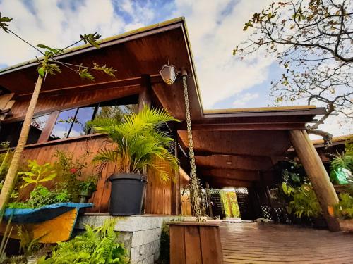 a wooden house with a porch with plants on it at Pousada Ilha Sul in Cananéia