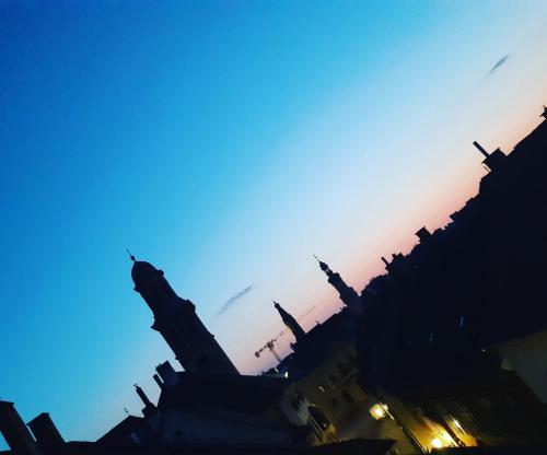 a silhouette of a building with the sunset in the background at Hotel Wollner in Sopron