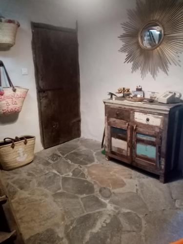 a room with a stone floor and a sink and a mirror at Echo du Maquis in Penta-Acquatella
