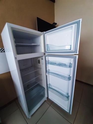 an empty refrigerator with its door open in a kitchen at Pousada Ilha Sul in Cananéia