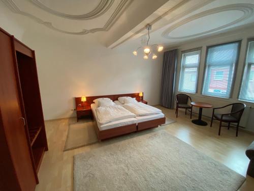 1 dormitorio con 1 cama, mesa y sillas en Passage 84 - Hotel & Café en Heilbad Heiligenstadt