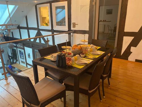 a dining room table with chairs and food on it at Passage 84 - Hotel & Café in Heilbad Heiligenstadt