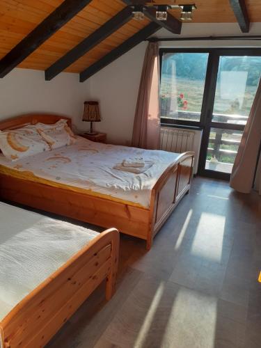 a bedroom with two beds and a large window at Pensiunea Natura Sadu in Sibiu