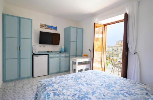 a bedroom with a bed and a kitchen with a balcony at La Casetta in Positano