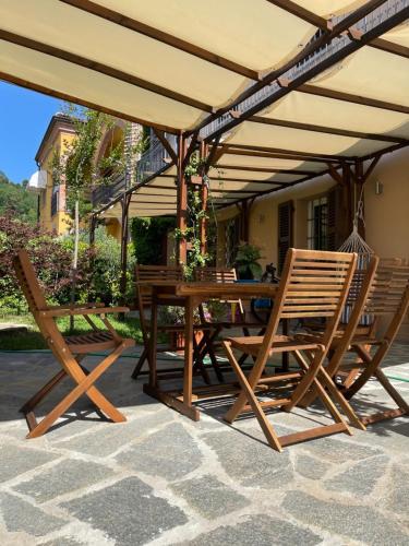 een houten tafel en stoelen onder een paraplu bij La Marchesa in Magliano Alfieri