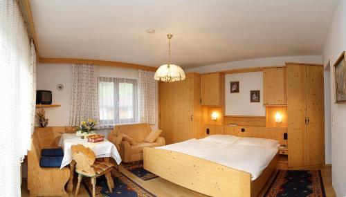 1 dormitorio con 1 cama grande y 1 mesa en Gästehaus Anker en Walchsee