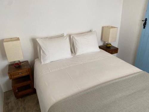 1 dormitorio con 1 cama blanca y 2 mesitas de noche en São Vicente, en Vila Nova de Milfontes