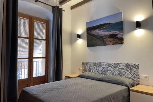 Un dormitorio con una cama y una ventana grande. en Casa Ferrers piso 2 Piso reformado en el casco antiguo de Tarragona, en Tarragona