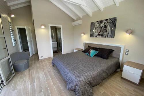 a bedroom with a bed and a painting on the wall at Villa Manzana : neuve 4ch 4sdb 2 piscines - LUXE in Saint-François