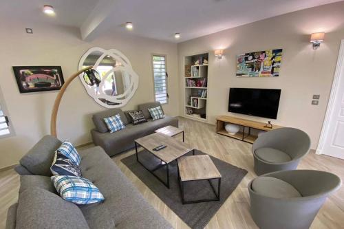 a living room with a couch and a tv at Villa Manzana : neuve 4ch 4sdb 2 piscines - LUXE in Saint-François