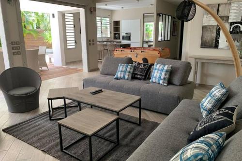 a living room with a couch and a table at Villa Manzana : neuve 4ch 4sdb 2 piscines - LUXE in Saint-François
