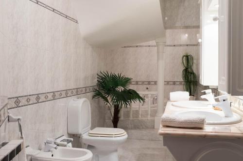 a white bathroom with a toilet and a sink at Moradia em Vilar dos Prazeres in Ourém