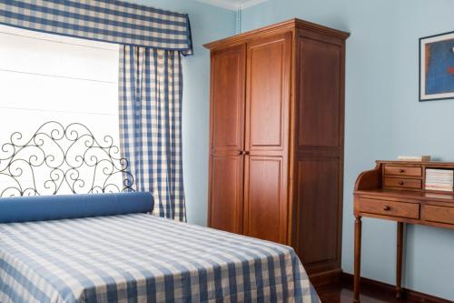 a bedroom with a bed and a wooden cabinet at Moradia em Vilar dos Prazeres in Ourém