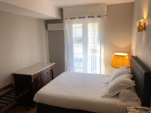 a small bedroom with a bed and a window at 29 Promenade des Anglais in Nice