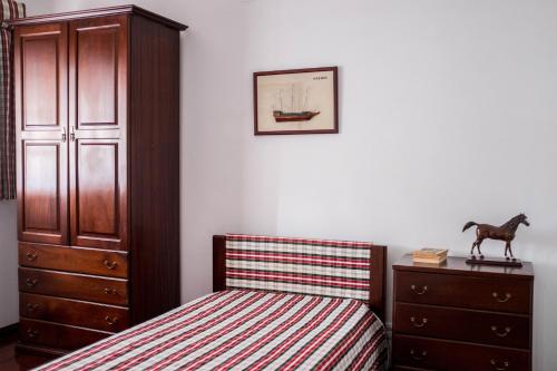 a bedroom with a bed and a dresser at Moradia em Vilar dos Prazeres in Ourém