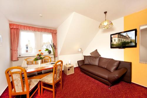 a living room with a couch and a table at Ferienhotel Bernstein in Trassenheide