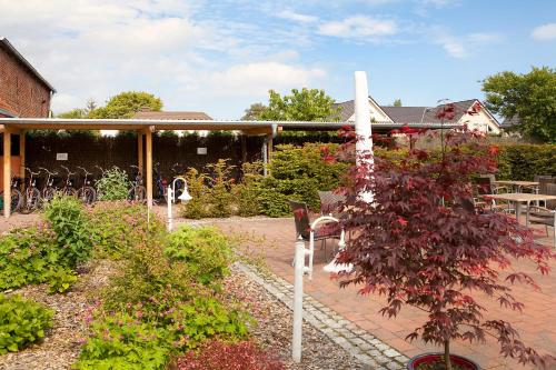 a garden with flowers and a cross in front of a building at Ferienhotel Bernstein in Trassenheide