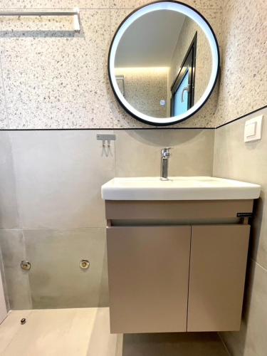 a bathroom with a sink and a mirror on the wall at Agora LX Studios & Suites in Thessaloniki