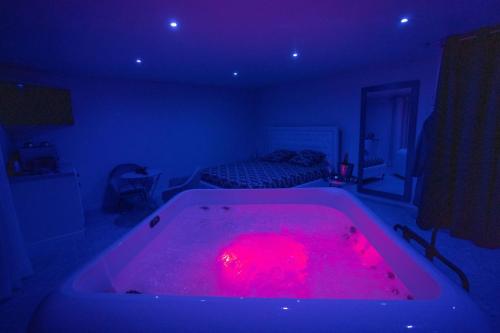 a bath tub with a red light in a room at LES SUITES LOVE 1 SPA VUE MER PISCINe in Marseille