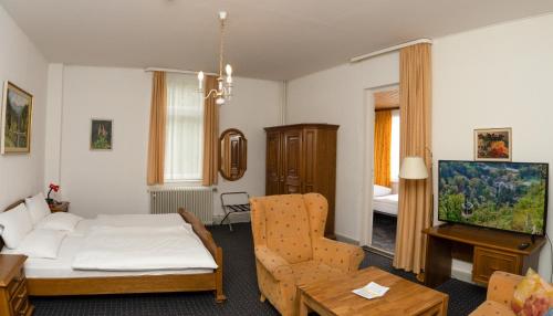 a living room with a couch and a tv at Villa Feise in Bad Harzburg