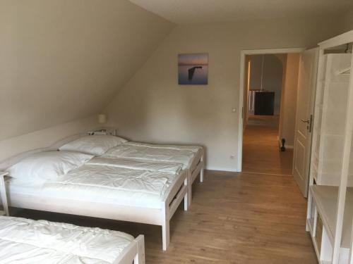 two twin beds in a room with a hallway at Landhaus von Frieling - Neuenkirchen in Neuenkirchen