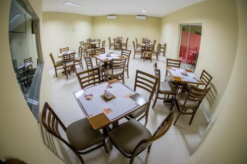 einen Blick über ein Restaurant mit Tischen und Stühlen in der Unterkunft K Hotel in Presidente Venceslau
