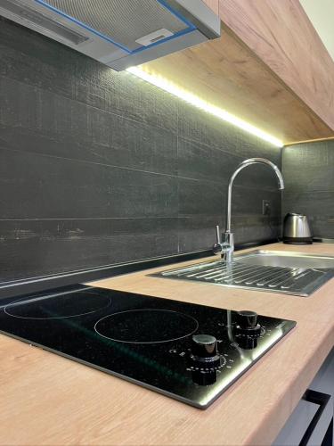 a kitchen counter with a sink and a stove at Agora LX Studios & Suites in Thessaloniki