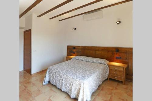 1 dormitorio con cama y cabecero de madera en Ca Buganvilla. El corazón de la huerta valenciana, en Meliana