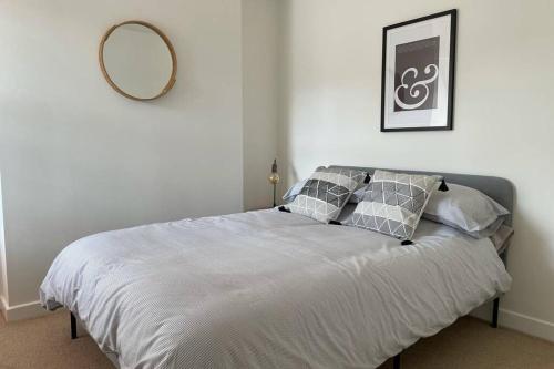 a bed in a bedroom with a mirror on the wall at Apartment with stunning views of Menai Strait. in Menai Bridge