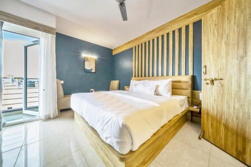 a bedroom with a large bed and a window at Air Avenue Hotel - Airport in Devanhalli