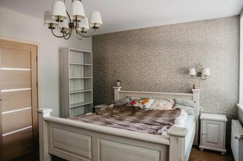 um quarto com uma cama branca e uma parede em Lovely apartment for families and couples em Liepāja