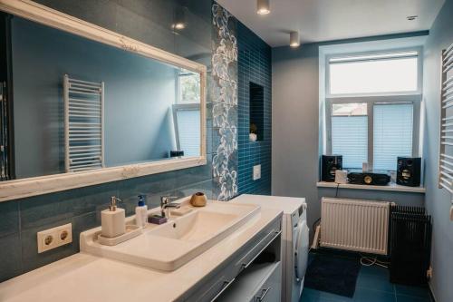 y baño con lavabo y espejo. en Lovely apartment for families and couples en Liepāja