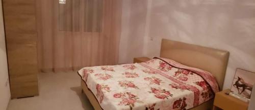 Schlafzimmer mit einem Bett mit einer roten und weißen Decke in der Unterkunft Zayatine wahat in El Aouina