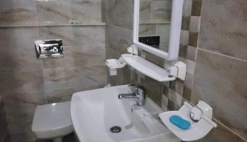 a bathroom with a white sink and a toilet at Zayatine wahat in El Aouina