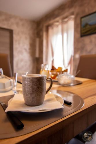 a table with a coffee cup and plates on it at Les escargots du mont in Tanis