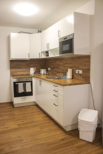 a white kitchen with a sink and a microwave at Apartmán Svoboda nad Úpou in Svoboda nad Úpou