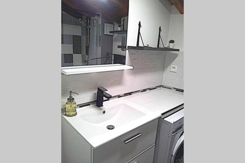 a bathroom with a sink and a mirror at Appartement en duplex - tout confort plein-centre in Lavaur