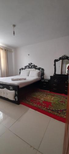 a bedroom with a bed and a rug on the floor at Furnished Homes Nakuru with pool & GYM in Nakuru