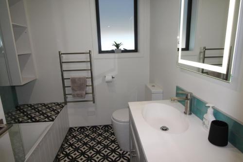 een badkamer met een witte wastafel en een toilet bij Hawea Mountain cottage in Lake Hawea